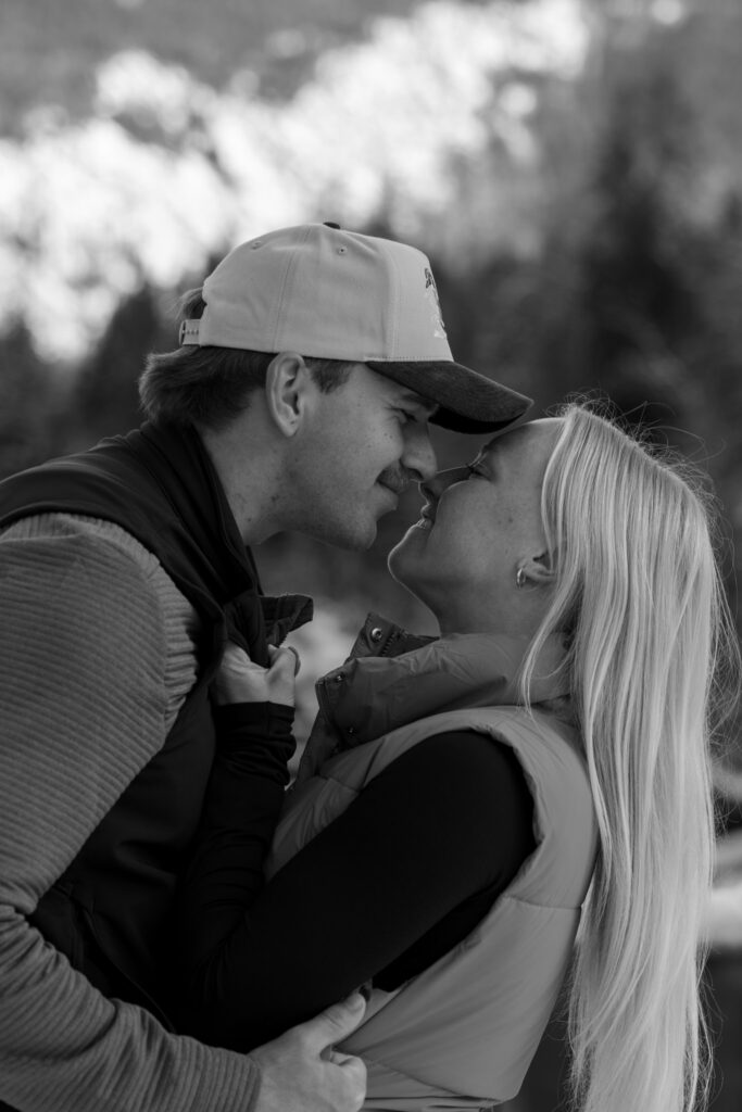 Black and white close up of an engaged couple about to kiss on Belton Bridge near the West Glacier entrance to Glacier National Park — Lindsey and Ethan — Glacier National Park Winter Engagement — Stacy Edwards Photography