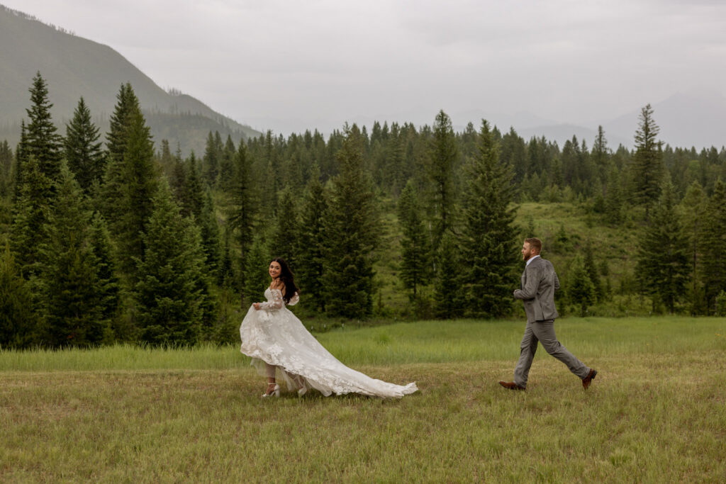 Groom chasing bride in the rain at Belton Stage Park near Glacier National Park | Stacy Edwards Photography