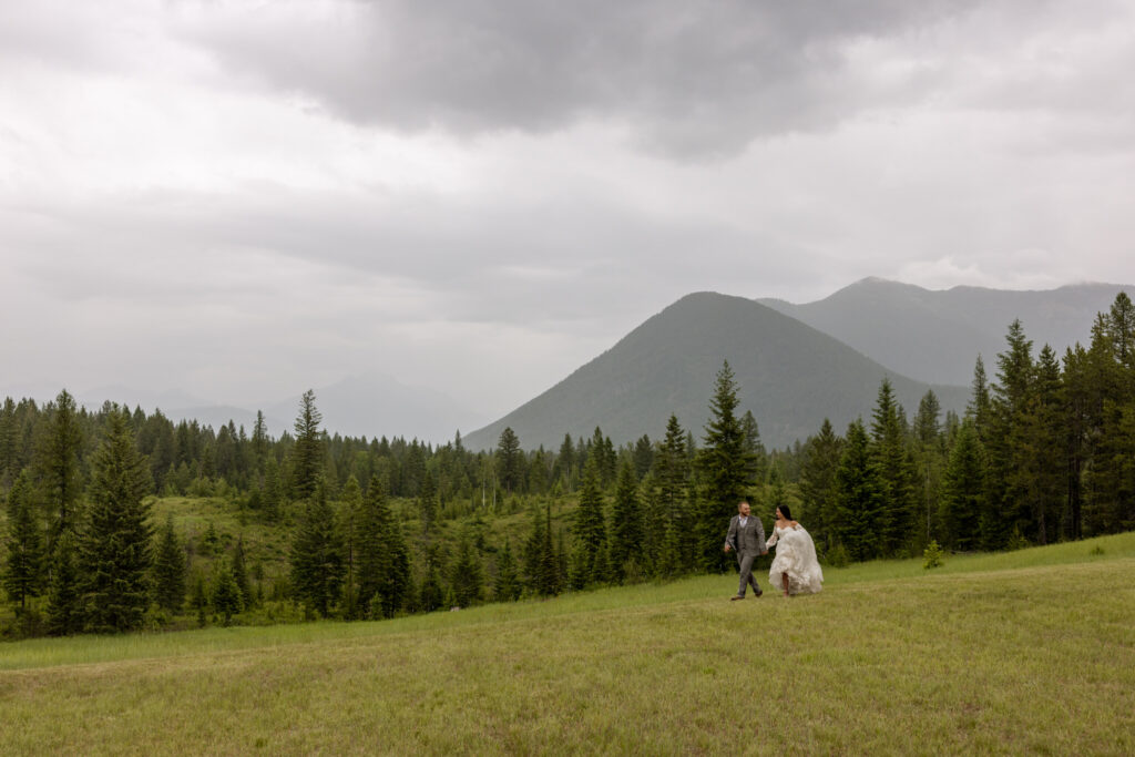 Bride and groom smiling at each other while walk at Belton Stage Park in Flathead County | Stacy Edwards Photography